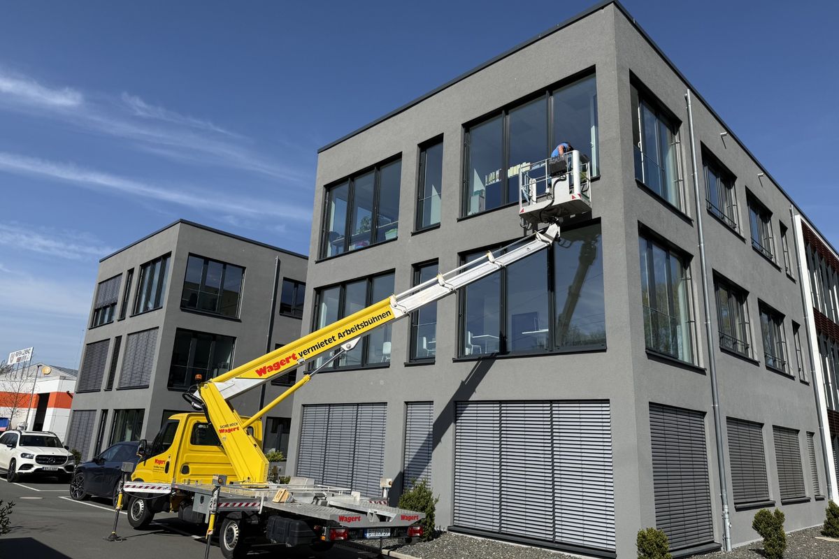 Glasreinigung an einem Bürogebäude mit Hubarbeitsbühne